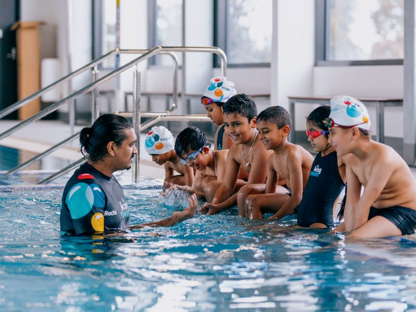 Kingswim teacher instructing students in a swimming lesson